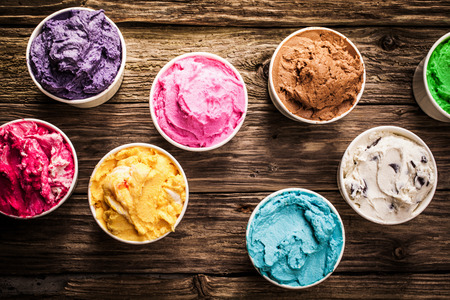 ice cream: Lựa chọn các hương vị sành ăn của kem Ý trong màu sắc sống động phục vụ trong chậu nhựa cá nhân trên một chiếc bàn gỗ mộc mạc cũ tại một tiệm kem, nhìn trên cao