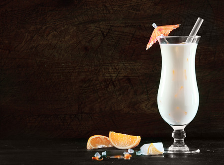 coconut: Delicious pina colada cocktail with rum, cream of coconut and pineapple for an exotic beverage to celebrate the Christmas and New Year festive season, on black with copyspace