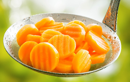 a carrot: Khỏe mạnh luộc hoặc hấp nhăn cắt lát trang trại cà rốt tươi trong một cái môi bếp sẵn sàng để được phục vụ như một đệm cho một bữa ăn Kho ảnh
