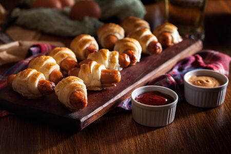 Pigs in blankets. mini sausages wrapped in puff pastry. dark mood