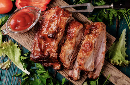 grilled pork: Sườn nướng ngon ướp với nước sốt cay Phết và ăn kèm với rau tươi xắt nhỏ vào một mộc mạc thớt gỗ cũ trong một nhà bếp nước. Top xem. Kho ảnh