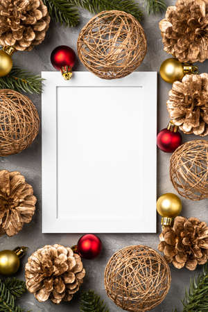Christmas composition with empty picture frame. golden ornament, pine cones and fir needles decorations. mock up greetings card template