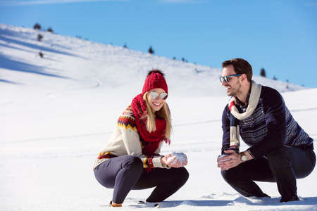 雪合戦 冬のカップルが楽しんで屋外の雪で遊ぶ 若い楽しい幸せな多民族カップル の写真素材 画像素材 Image