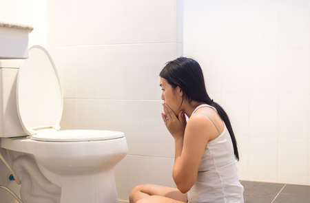 Pregnant female nausea in toilet,Asian woman with morning sickness Stock Photo