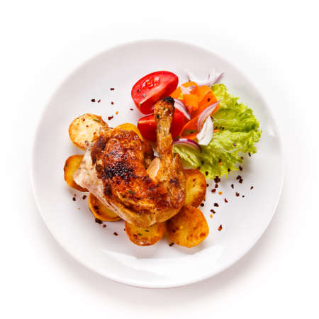Roast chicken leg with chips on white background Stockfoto