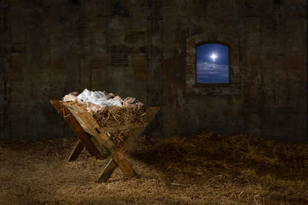 Manger in barn with window showing Christmas star - 63774030