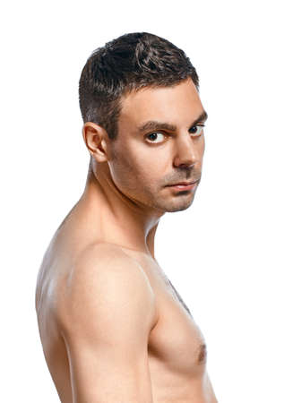 振り向きざまに孤立した白い背景に裸の胴体とジーンズに若い男の肖像 の写真素材 画像素材 Image