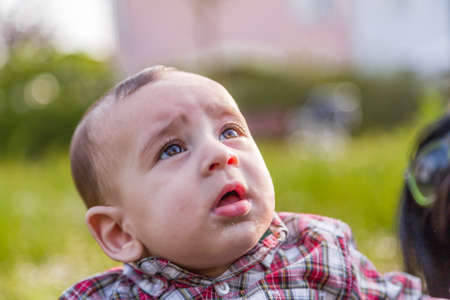 赤い格子縞のシャツとベージュのパンツで明るい茶色の髪でかわいい生後 6 ヶ月の赤ちゃんは口の中で唾液の泡を作ってください の写真素材 画像素材 Image 4299