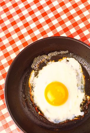 fried eggs from one eggs in frying pan on red cloth stock photo
