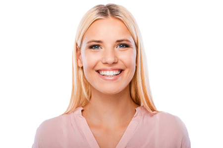 Ella consiguió hermosa sonrisa. Retrato de mujer joven alegre mirando a la cámara y sonriendo mientras está de pie contra el fondo blanco Foto de archivo - 42730583