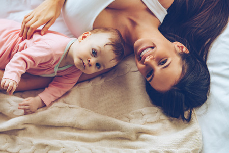 Guten Morgen Sonnenschein Draufsicht Der Netten Schonen Jungen Frau Die Ihr Baby Beim Lugen Im Bett Umarmt Lizenzfreie Fotos Bilder Und Stock Fotografie Image 53684320