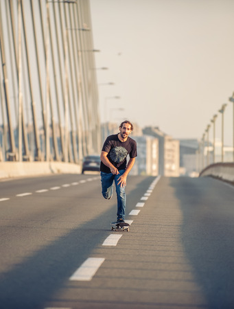 professional skateboarder riding a skate over a city road bridge