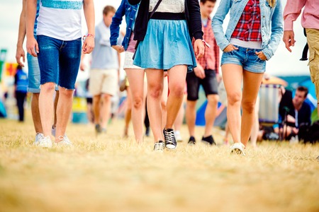 Gli adolescenti non riconoscibili alla tenda festival di musica a piedi, di sole estivo, close up di gambe Archivio Fotografico - 52867152