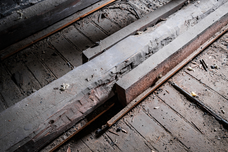 Weak wooden floor beam in old attic / loft with support construction -