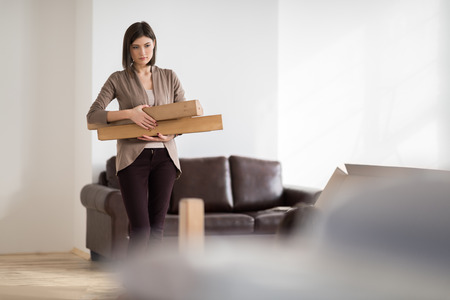 Young woman doing DIY repairs at home putting together self assembly furniture - 39577013