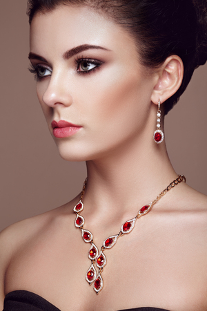Fashion portrait of young beautiful woman with jewelry. Brunette girl. Perfect make-up. Beauty style woman with diamond accessories Фото со стока