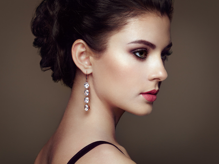 Fashion portrait of young beautiful woman with jewelry. Brunette girl. Perfect make-up. Beauty style woman with diamond accessories Фото со стока