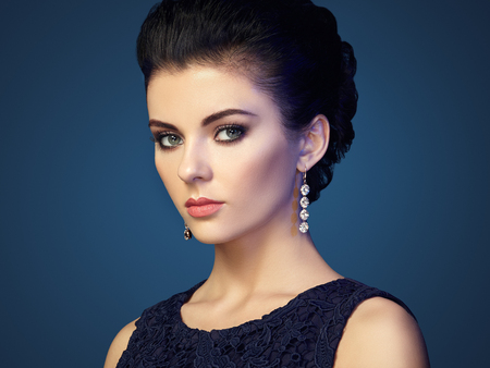 Fashion portrait of young beautiful woman with jewelry. Brunette girl. Perfect make-up. Beauty style woman with diamond accessories Фото со стока
