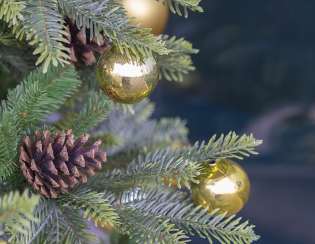 Close Up Pine Tree Cone And Golden Christmas Balls On Artificial With Blue Bokeh Close Up Pine Tree Cone And Golden Christmas Balls On Artificial With Blue Bokeh