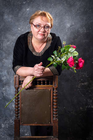 Middle Aged Woman In Blue Dress With Flowers Studio Portrait.