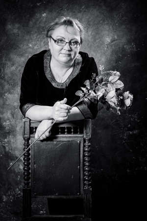 Middle Aged Woman In Blue Dress With Flowers Studio Portrait.