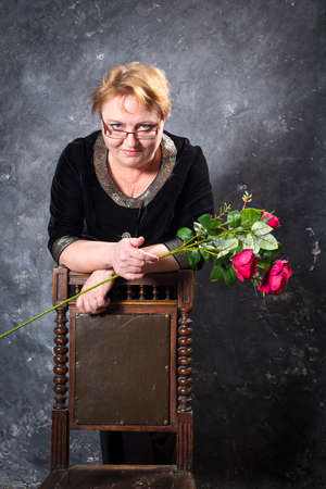 Middle Aged Woman In Blue Dress With Flowers Studio Portrait.