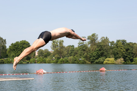 Public Swimming Pools With Diving Boards man jumping off diving board at a public swimming pool stock photo Public Swimming Pools With Diving Boards man jumping off diving board at a public swimming pool stock photo