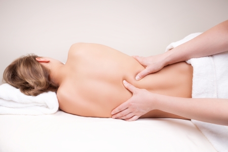 Massage: Глубокий массаж тканей на женщины середине задней на выпрямляющих spinae мышц Фото со стока