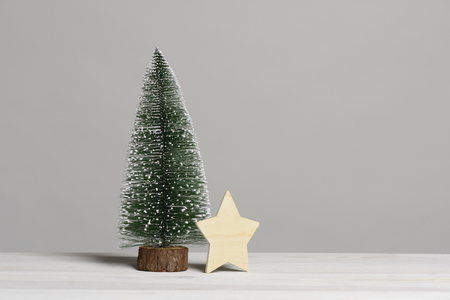 Small Christmas Tree On White Wooden Table And Star Card Concept Stock Photo Small Christmas Tree On White Wooden Table And Star Card Concept Stock Photo