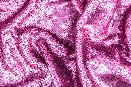 Pink purple shiny fabric with sequins, abstract background. close-up.