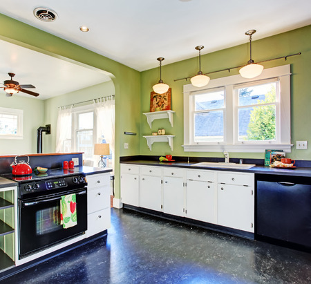 kitchen room with green walls white cabinets and black appliances