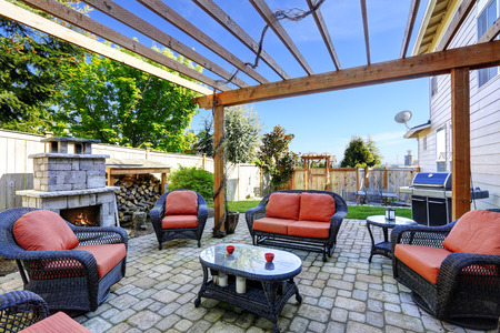 Backyard mysig uteplats med rottingmöbler set och tegel spis ...