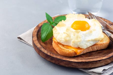 Nuage à la mode ou plat d'œufs moelleux sur une assiette en bois, horizontal, espace de copie