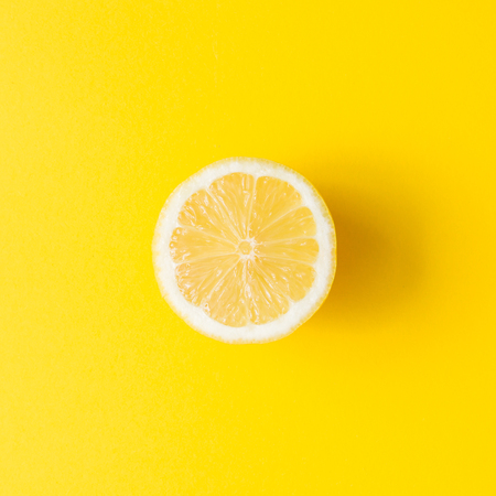 Lemon on vivid yellow background. Minimal summer concept. Flat lay.
