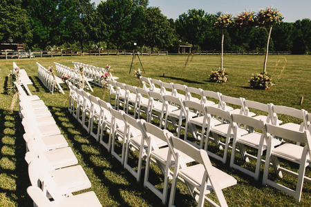 White Garden Chairs Stand In Rows Before A Wedding Altar Stock Photo White Garden Chairs Stand In Rows Before A Wedding Altar Stock Photo