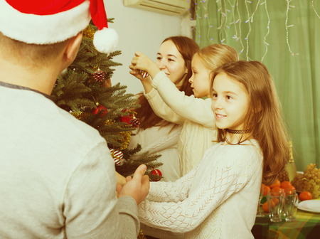 four happy people decorating christmas tree at home stock photo 65665200 - People Decorating A Christmas Tree four happy people decorating christmas tree at home stock photo 65665200 - People Decorating A Christmas Tree