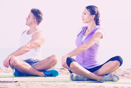 あぐらの男と海辺に女の子練習ヨガのポーズを笑顔 の写真素材 画像素材 Image