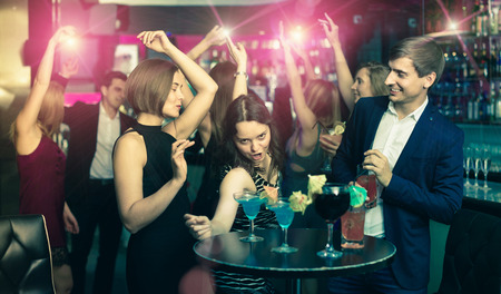 happy positive glad colleagues dancing on corporate party with