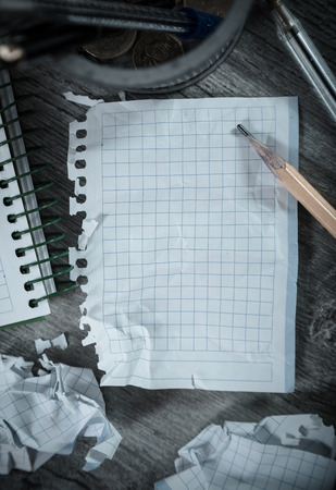 Crumpled empty pages and notebook lying on wooden surface