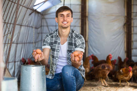 Jeune agriculteur tenant des oeufs frais