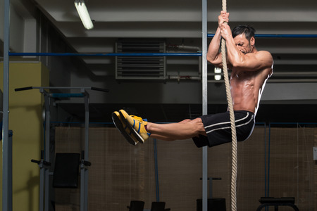 fitness rope climb exercise in fitness gym workout stock photo