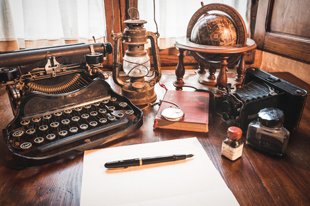 Vintage items, camera, pen, globe, clock, typewriter on the old desk - 38017710