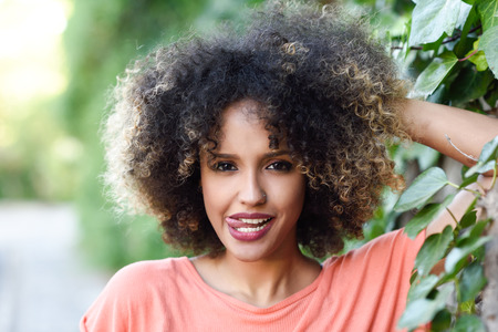 Black Woman With Tongue Out In An Urban Park Young Mixed Girl With Afro Hairstyle Black Woman With Tongue Out In An Urban Park Young Mixed Girl With Afro Hairstyle