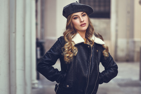 都市の背景に金髪ロシア人女性 通りで身に着けているベレー帽 黒革のジャケットとミニのスカート立っている美しい少女 長いウェーブのかかった髪の髪型と青目でかなりの女性 の写真素材 画像素材 Image