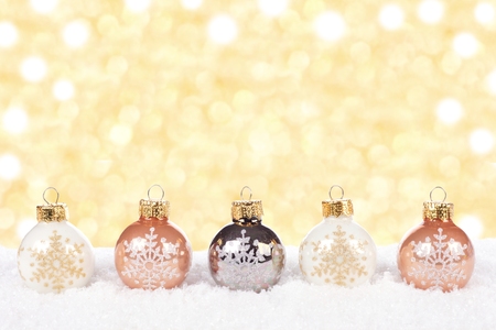stock photo white and gold christmas ornaments in snow with twinkling gold background - White And Gold Christmas Ornaments stock photo white and gold christmas ornaments in snow with twinkling gold background - White And Gold Christmas Ornaments