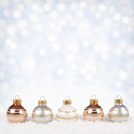 stock photo white silver and gold christmas ornaments in snow with twinkling gold background - White And Gold Christmas Ornaments stock photo white silver and gold christmas ornaments in snow with twinkling gold background - White And Gold Christmas Ornaments