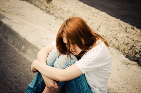 sad lonely: Beautiful young sad girl sitting on asphalt