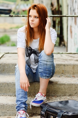 sad lonely: Beautiful young sad girl sitting on the staircase