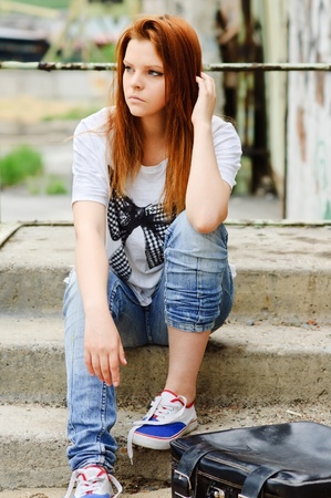 Beautiful young sad girl sitting on the staircase - 10703108