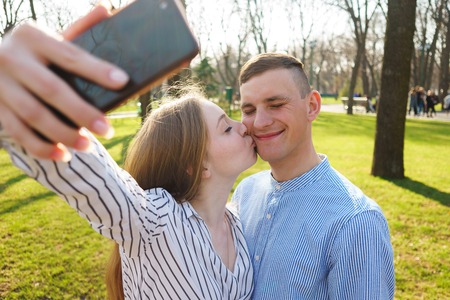 Happy Smiling Couple Taking Selfie, Kiss And Take Pictures On Sm